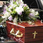 Coffin with flower arrangement in a hearse