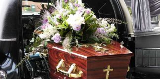 Coffin with flower arrangement in a hearse