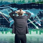 Person in front of falling stock market graph