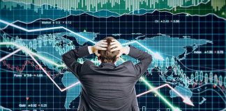 Person in front of falling stock market graph