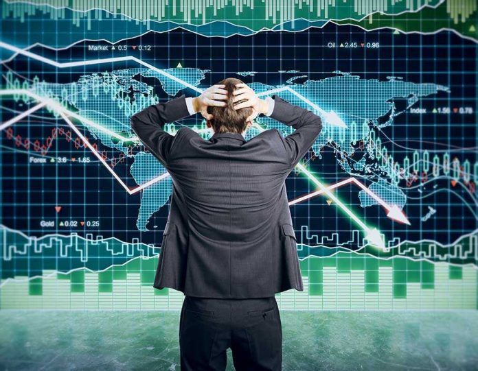 Person in front of falling stock market graph