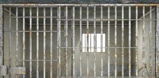 Empty rusty prison cell with a small window