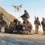 Soldiers operating a drone in a desert environment