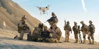 Soldiers operating a drone in a desert environment