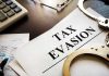 Tax evasion document with handcuffs calculator and papers