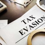 Tax evasion document with handcuffs calculator and papers