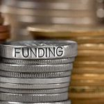 Stack of coins labeled funding with other coins stacks