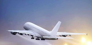 An airplane taking off from an airport runway against a twilight sky