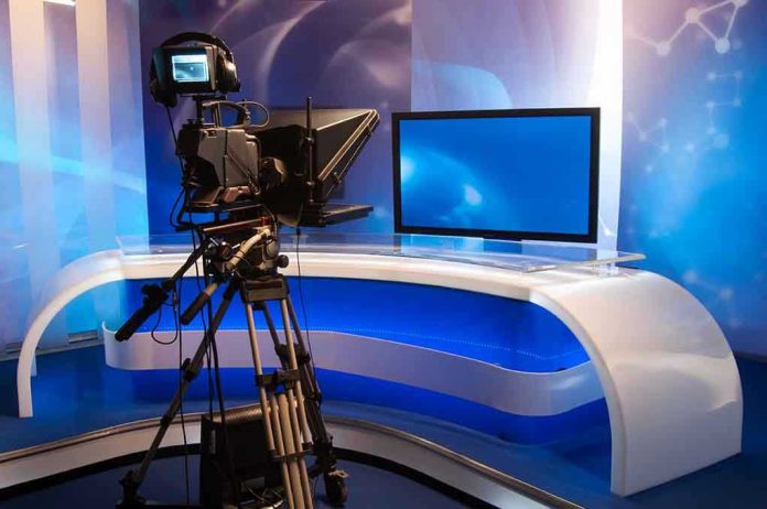 TV studio with camera and empty anchor desk