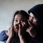 Mother’s Story SHATTERED: Kidnapping or Something Worse? Man holding woman's mouth, gesturing silence.