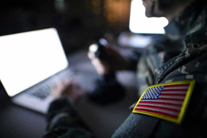 Soldier using laptop with US flag patch visible