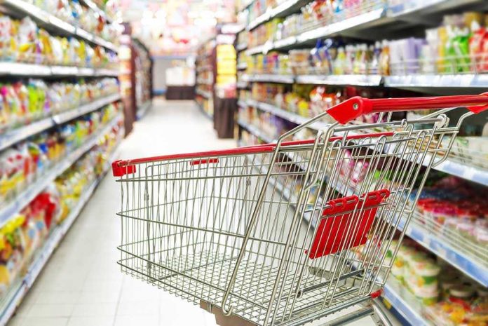 Empty shopping cart in grocery store aisle