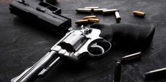 Revolvers and bullets on a dark surface