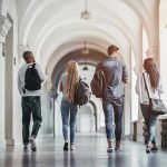Four students walking in a corridor together