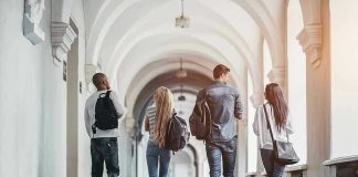Four students walking in a corridor together