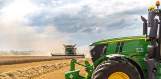 A green tractor in a wheat field