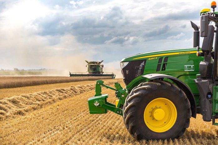 A green tractor in a wheat field