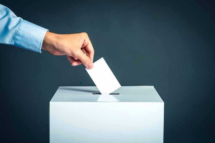Hand placing ballot into voting box