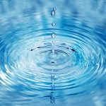 Water droplets creating ripples on a surface