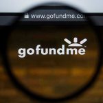 Magnifying glass over GoFundMe website logo.