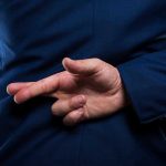 Police Chief’s Double Life EXPOSED Person crossing fingers behind their back in suit