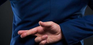 Person crossing fingers behind their back in suit