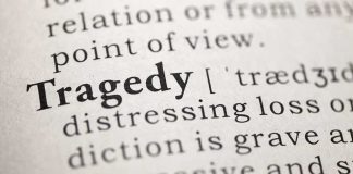 Close-up of the word Tragedy in a dictionary with its definition
