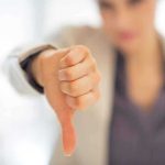 Businesswoman showing a thumbs down gesture in an office setting