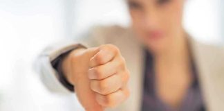 Businesswoman showing a thumbs down gesture in an office setting