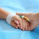 Child Euthanasia Trend Growing Two hands holding, one with medical IV attached.