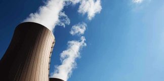 Cooling towers of a nuclear power plant emitting steam against a blue sky