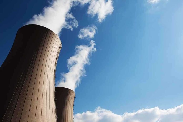 Cooling towers of a nuclear power plant emitting steam against a blue sky