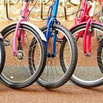 A row of colorful bicycles parked, showcasing their wheels and frames