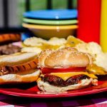 Food Brawl EXPLODES — 7 Arrested, Blood Everywhere A plate with a hamburger, hot dog, and potato chips on a picnic table