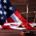 Scales of justice with American flag background.