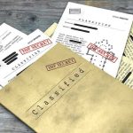 Classified documents with Top Secret stamps on wooden surface.