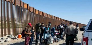 Border patrol agents interact with a group of people.