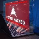 Warning sign System Hacked on laptop screen.