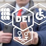 Person pointing at DEI symbols on glass.