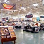 Supermarket interior with various food sections and displays.