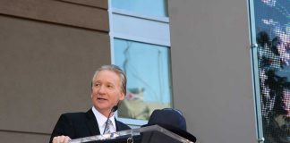 A man in formal attire speaking at a podium during a Hollywood Walk of Fame ceremony