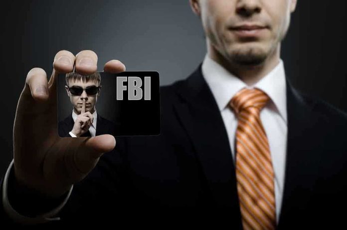 A man in a suit holding an FBI identification card while making a shushing gesture