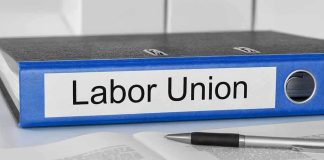 Blue binder labeled Labor Union beside papers and pen.