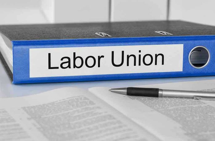229709788 Blue binder labeled Labor Union beside papers and pen.