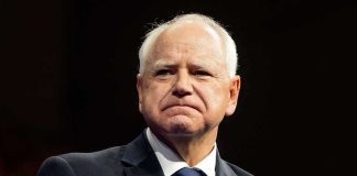 Man in suit with a U.S. flag pin.