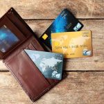 Predatory Rates Exposed Wallet with three credit cards on wooden surface