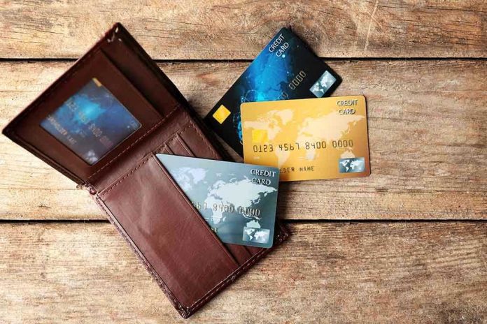Wallet with three credit cards on wooden surface