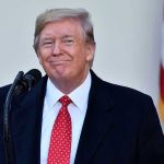 Trump’s ‘Bad Timing’ Stuns: Iran Over Family? Man in suit and tie speaking at podium.