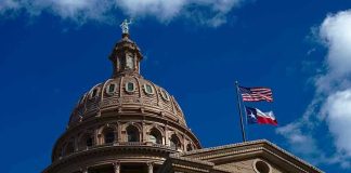 Fort Worth Principal Controversy EXPLODES Overnight Building dome with US and Texas flags, blue sky.