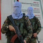 Hamas Chief Deif DEAD – Shocking Strike Outcome Masked soldiers holding rifles in front of a monument.
